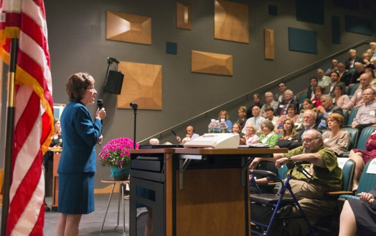 Susan Collins speaking to auditorium