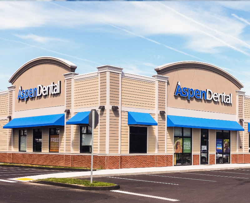 Blue, beige, and brick building with Aspen Dental logo