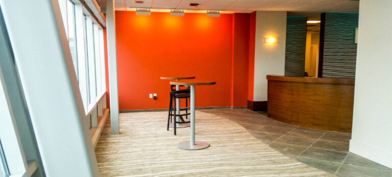 Orange wall and hightop seating tables