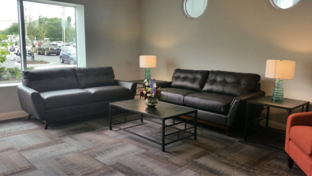 Sitting area with rug and black leather couches